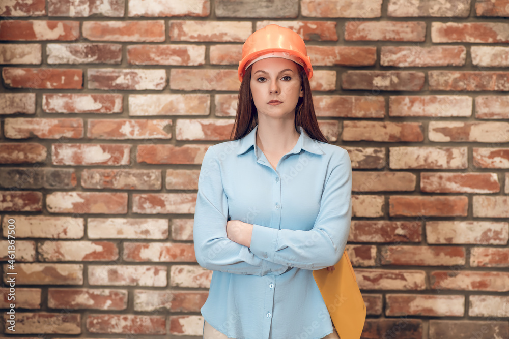 Woman in protective helmet with her arms crossed Woman in protective helmet with her arms crossed
