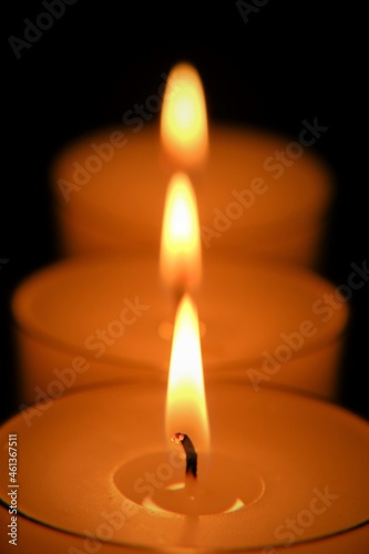 Candle row on black background..Candle flame.Candles background. Burning candles in the dark