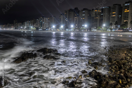 Night view of sea rocks with the background of Pitangueiras Beach with avenue and rise apartments na cidade de Guaruja  Sao Paulo state coast