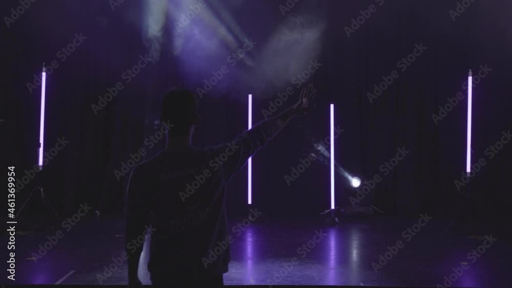 Director setting up empty stage with lights. Stage lights shining at studio. Lights flashing at