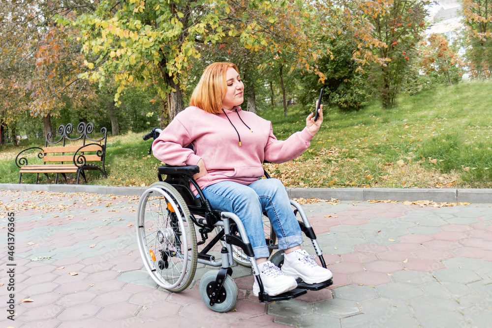 A disabled teenage girl in a wheelchair smiles and takes a selfie on a walk in the park. Full-fledged and a vibrant life for people with disabilities. Online communication.
A disabled teenage girl in a wheelchair smiles and takes a selfie on a walk in the park. Full-fledged and a vibrant life for people with disabilities. Online communication.