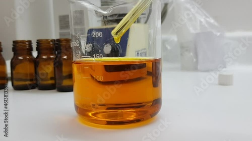 Analyzing a sample of rosehip oil in a beaker in the laboratory photo