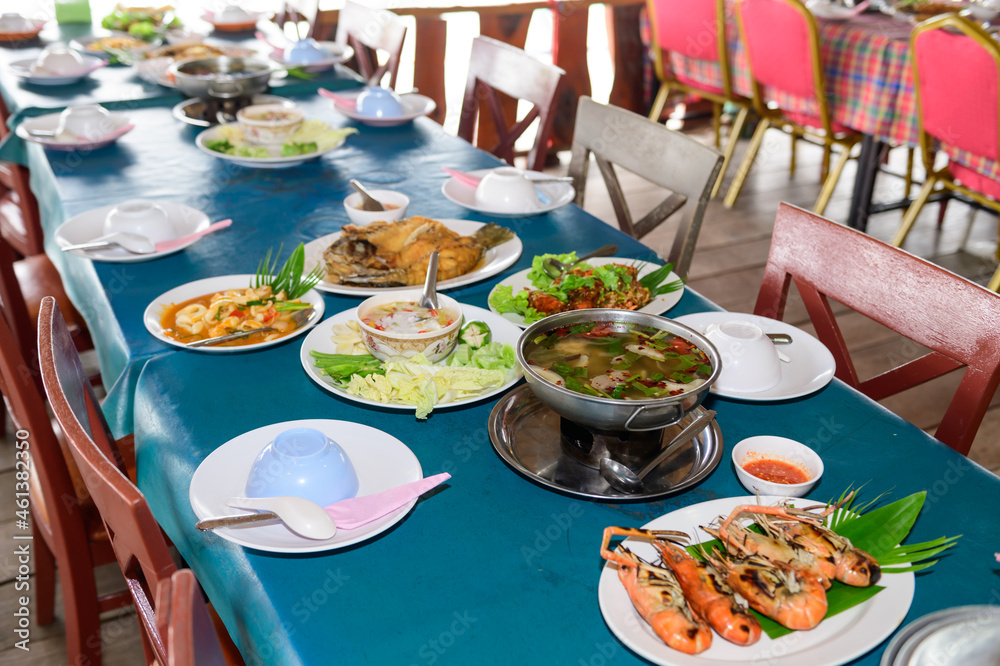Thai food such as tom yum, grilled shrimp, fried fish and fresh vegetable chili paste. on the table