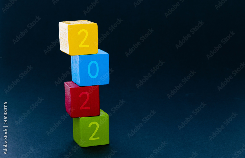 Colorful wooden building blocks with number 2022 stacking on black background Colorful wooden building blocks with number 2022 stacking on black background