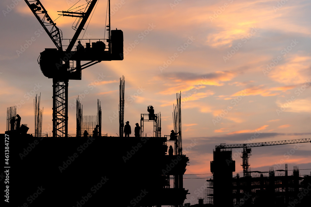 Silhouette of worker team on building site, construction site at sunset in evening time