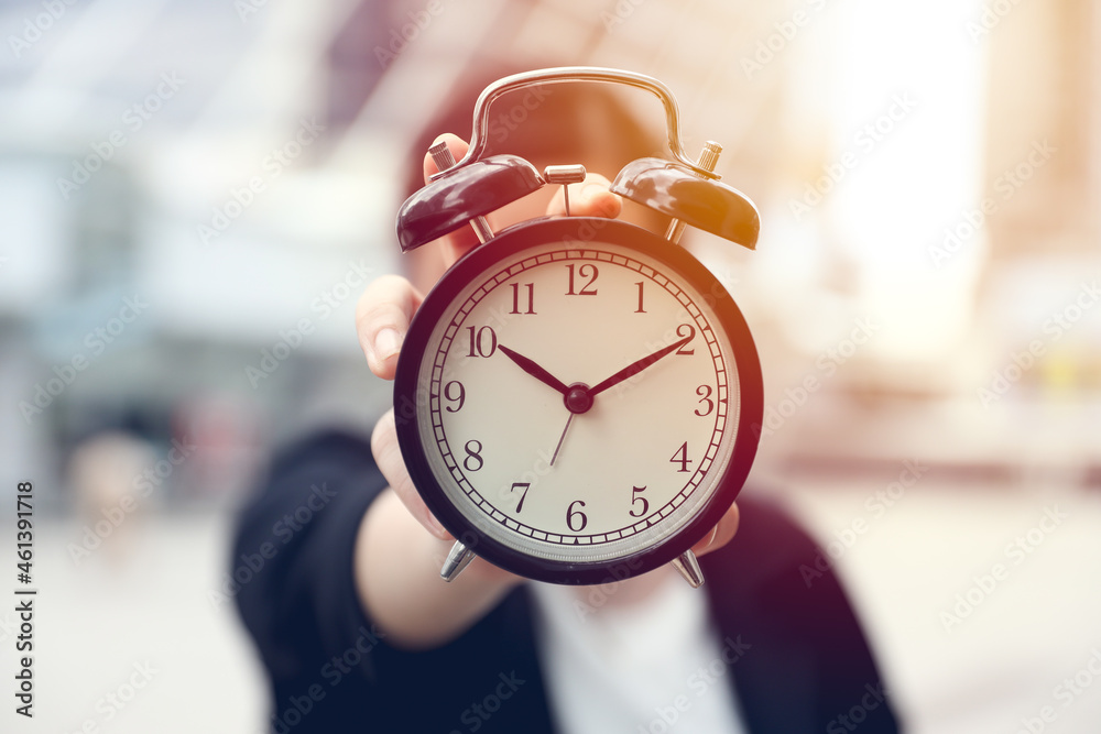 closeup business people hand holding alarm bell clock outdoor blur office city background closeup business people hand holding alarm bell clock outdoor blur office city background