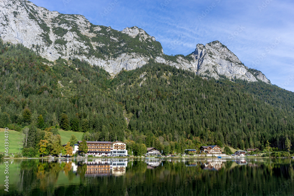 bavarian houses at the shore of a beautiful lake in the mountains with blue sky