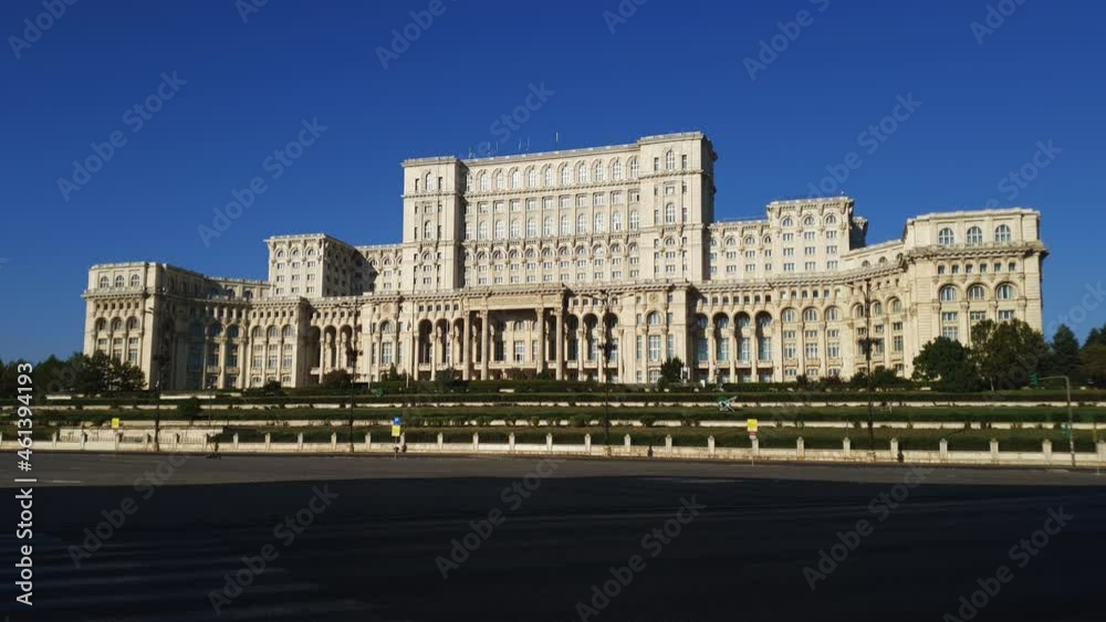Cars drive past Palace of Parliament. Bucharest, Romania. Static daytime shot Cars drive past Palace of Parliament. Bucharest, Romania. Static daytime shot