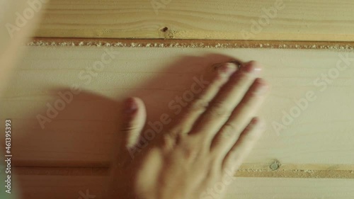 Hand brusing off wood shavings, slow motion
