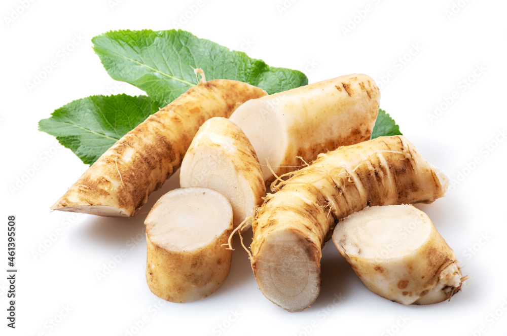 Horseradish roots and green leaves close up on the white background.