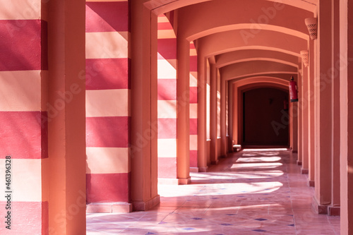 terracotta corridor with many arches in contrasting sunlight