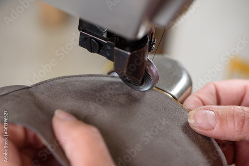 фотографія Female shoemaker hands stitching leather craft shoes on sewing machine