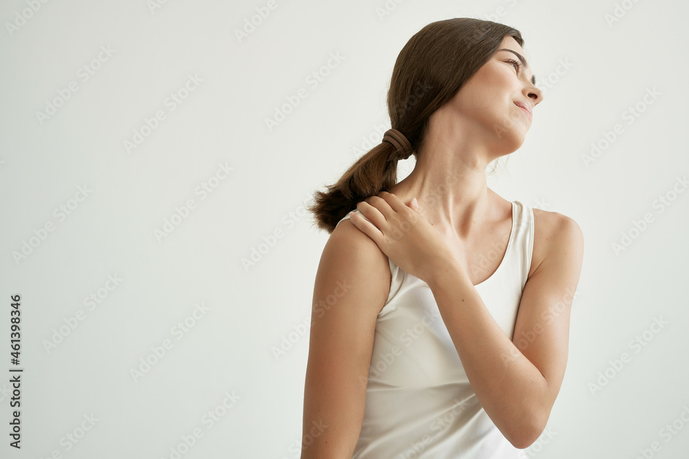 woman in white t-shirt holding hand health problem arthrosis