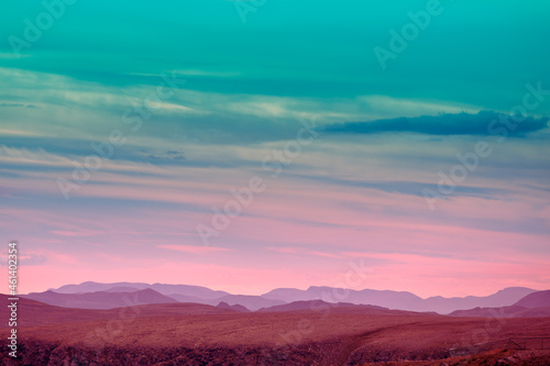 Silhouette of mountain ridge against sunset sky.