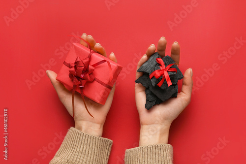 Woman with coal and Christmas gift on color background Fotobehang