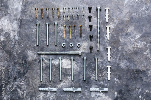 Set of different screws, bolts and dowels on grunge background