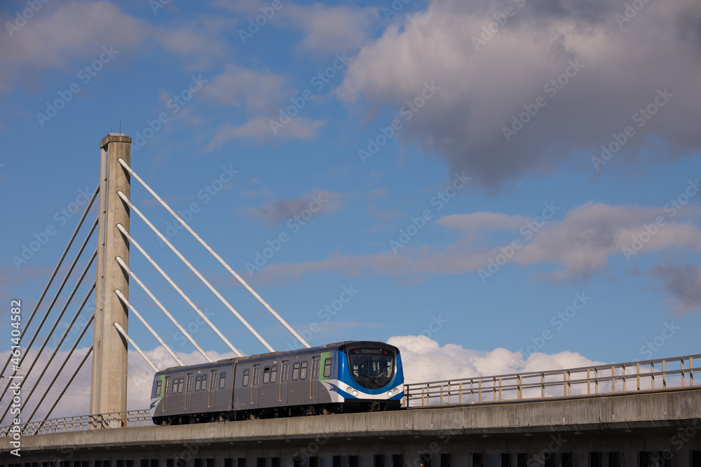 Fototapeta premium Skytrain passing Cable stayed bridge in cloudy and blue sky in Vancouver