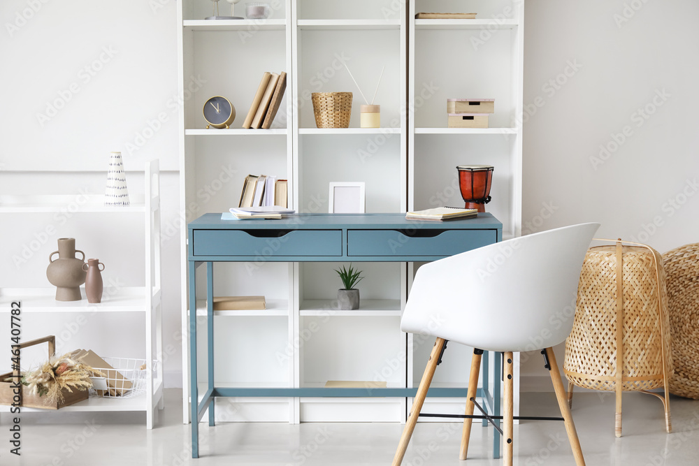 Blue desk near bookcase in room Blue desk near bookcase in room