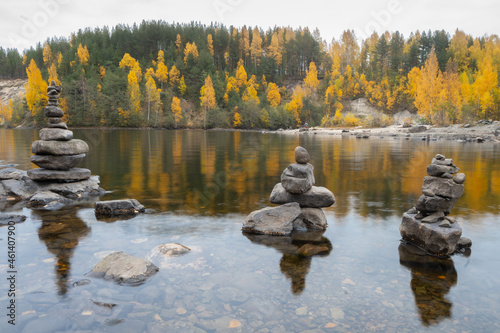 Pyramid of balanced zen stones, yellow and green trees, autumn and peace photo