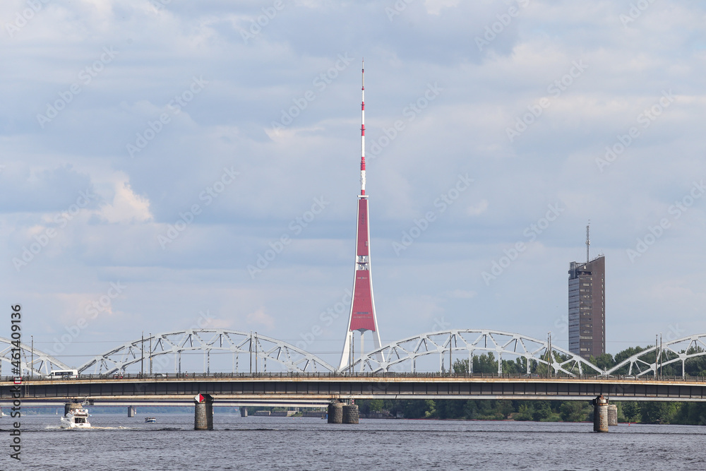 Cityscape view of transportation bridges over river Daugava and TV tower in background.