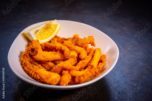 Wallpaper Mural Squid in batter with lemon on a black background, on a white plate Torontodigital.ca