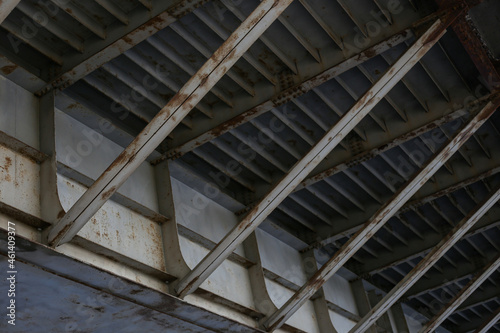 Close-up shot of old metal mesh bridge construction with signs of rust.