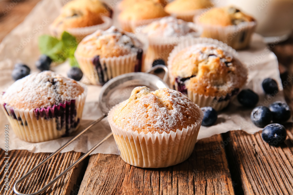 Tasty blueberry muffins on wooden background, closeup Tasty blueberry muffins on wooden background, closeup