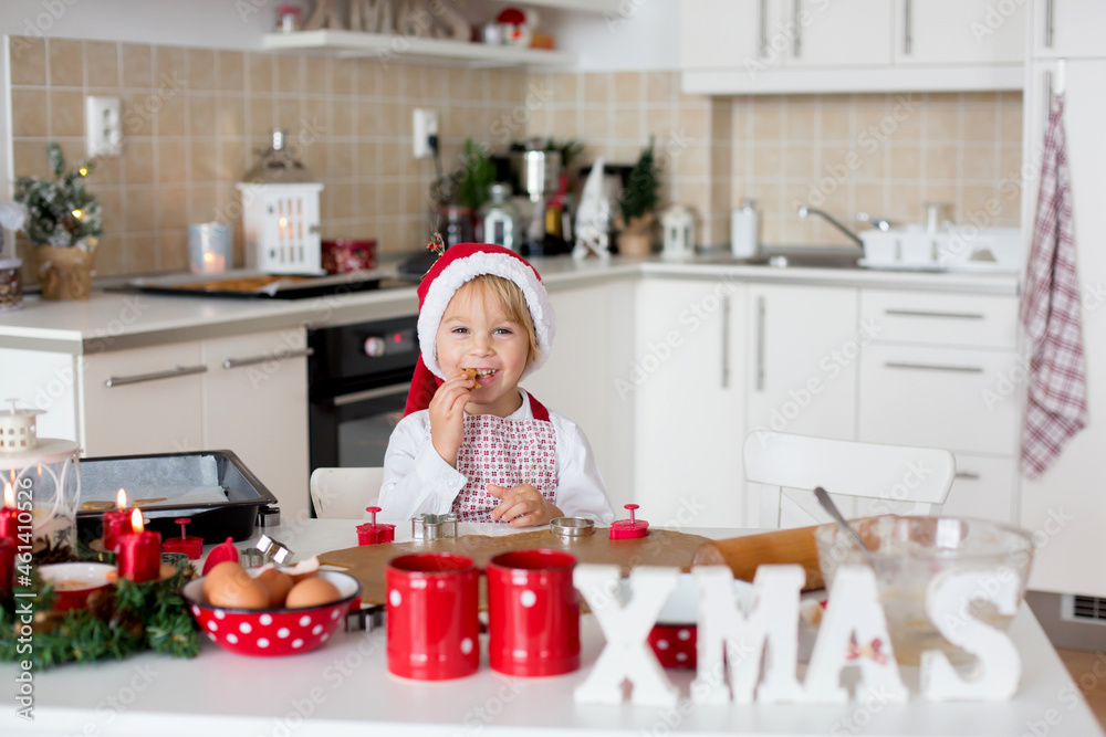 Cute blond child, boy and his mom, baking christmas cookies at home Cute blond child, boy and his mom, baking christmas cookies at home