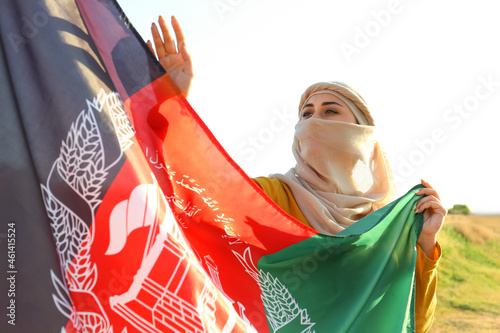Muslim woman with flag of Afghanistan outdoors