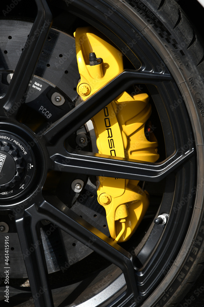 detail of an alloy rim with yellow brake caliper and carbon ceramic disc of  a Porsche 911 in the paddock of the Mugello circuit. Italy Stock Photo |  Adobe Stock