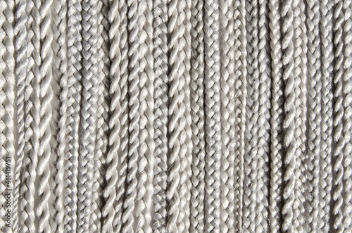 Many synthetic fiber braids with different weaves. Texture, background. Hairdressing material - kanekalon, used for weaving synthetic braids and making wigs.