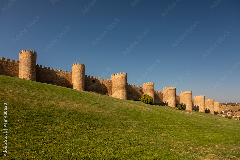 Wall of Avila with clear blue sky and wide lawns