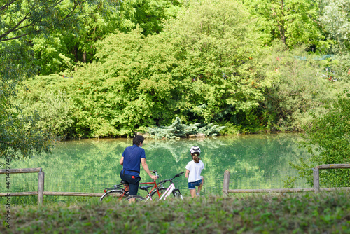 Turin, Italy. June 6, 2021. View of the Pellerina Park where father and daughter stop with their bicycles to look at the lake.