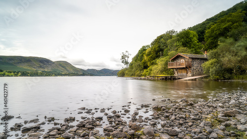 Ullswater in the Lake District National Park, England. The shoreline rocks and boathouse leading out into the Lake District fells and mountains in the background.