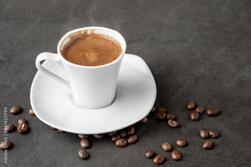 Fototapeta premium Turkish coffee over smoke and coffee beans on dark stone table
