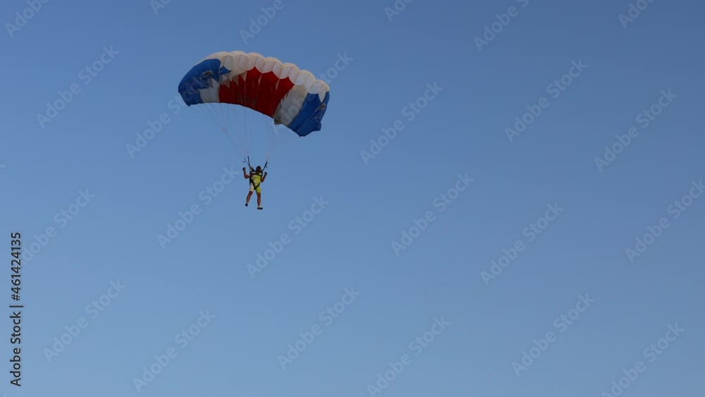 National Parachuting Championship: Parachutist is flying slowly down with an open parachute. Skydiving, gliding, parachute jump National Parachuting Championship: Parachutist is flying slowly down with an open parachute. Skydiving, gliding, parachute jump