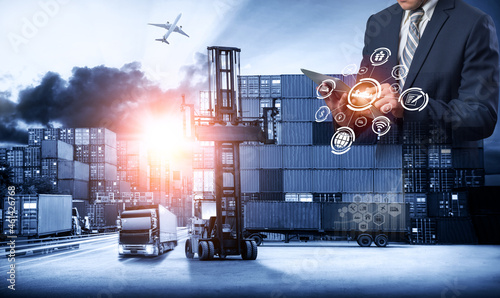 Multiple exposures of Businessman touching tablet for analyze stock at logistics port and world map with Delivery network distribution on background, transportation trading business concept