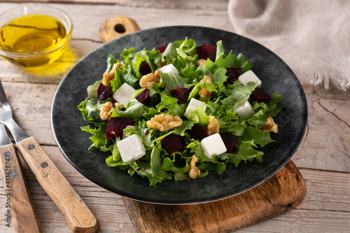 Beetroot salad with feta cheese,lettuce and walnuts on rustic wooden table	