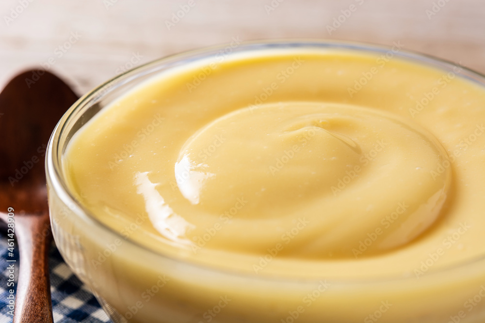 Pastry cream in a bowl on wooden table Pastry cream in a bowl on wooden table