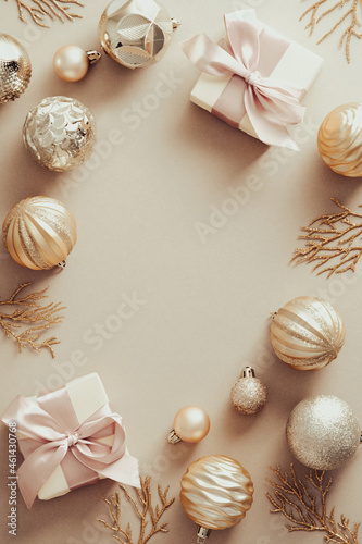 Christmas postcard design. Frame made of elegant Christmas decorations, gifts, snowflakes on pastel beige background. Merry Christmas and Happy New Year greeting card template.