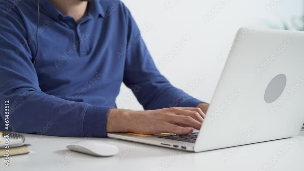 Handheld closeup of man typing on laptop in office Handheld closeup of man typing on laptop in office