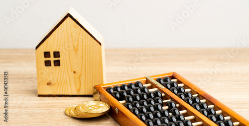 brown house and golds coin wiht chinese abacus on the brown table front view and copy space photo