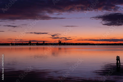 Fototapeta Naklejka Na Ścianę i Meble -  Stralsund bei Nacht - Sonnenuntergang.
Blick auf die Stadt von Altefähr auf Insel  Rügen,
Deutschland 2021
