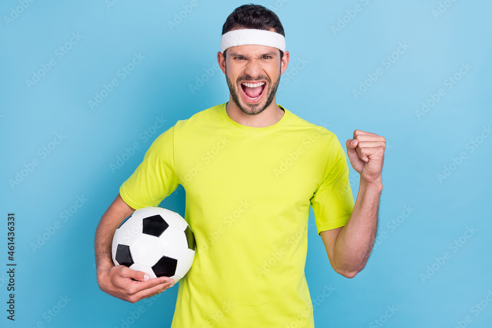 Naklejka premium Photo of cheerful excited crazy happy man hold hand football winner fist champion isolated on blue color background