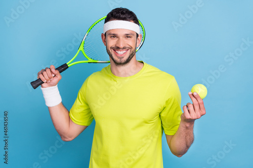 Photo of happy positive cheerful cool young man tennis player hold racket ball smile isolated on blue color background © deagreez