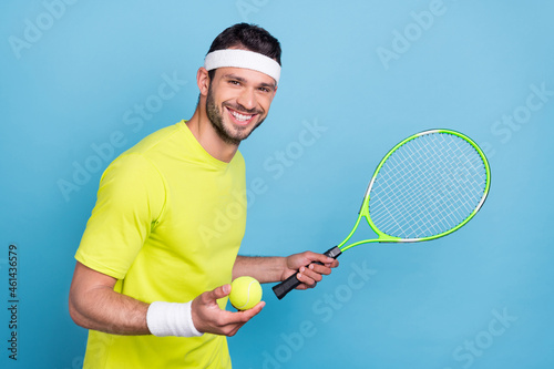 Portrait of attractive cheerful guy playing tennis active rest isolated over bright blue color background © deagreez