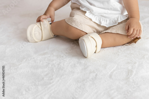 ベビーシューズを履いて、座っている赤ちゃんの足(1歳2か月、女の子、日本人)