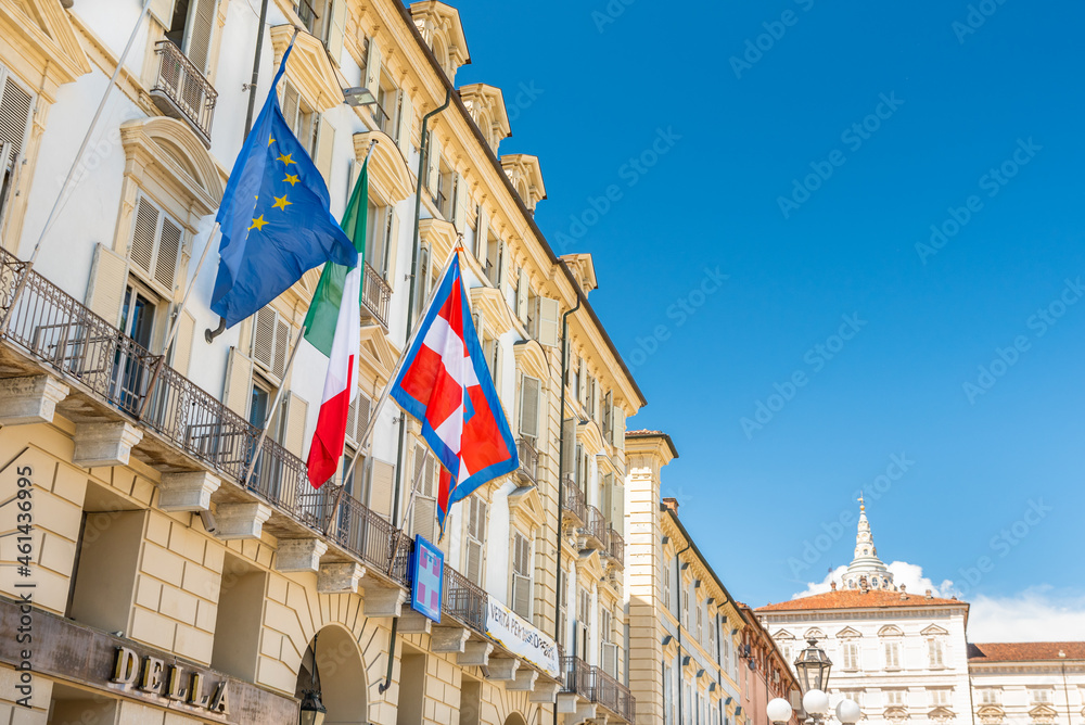 Fototapeta premium Turin, Italy. May 12, 2021. The flag of Europe, Italy and the Piedmont Region flutters on the facade of the historic building seat of the Government of the Piedmont Region in Piazza Castello.
