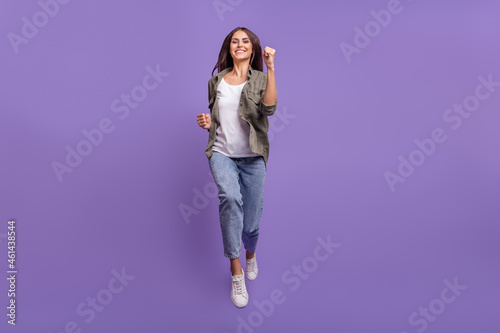 Full length photo of cool young brunette lady run wear shirt jeans shoes isolated on violet background