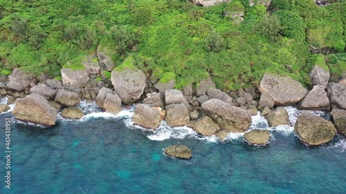 Aerial top down view tracking left shot along the rocky shore capturing beautiful seascape and waves crashing the coastal rocks at Xiaoliuqiu Lambai Island, Pingtung county, Taiwan. photo